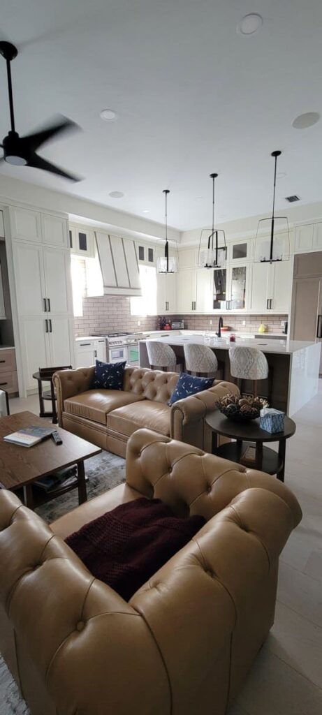 Completed kitchen renovations in Bonita Springs with a marble island, hanging lights and all white cabinets