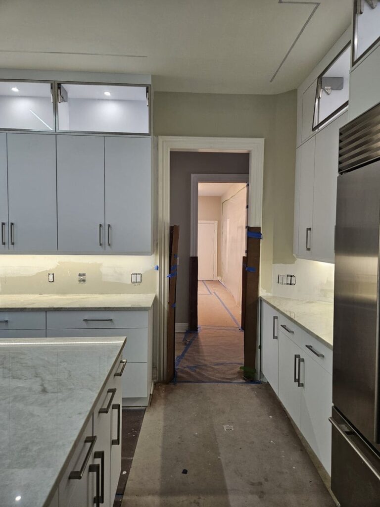 20230810_163917 All white kitchen with custom made cabinets, white countertops and a fridge on the right